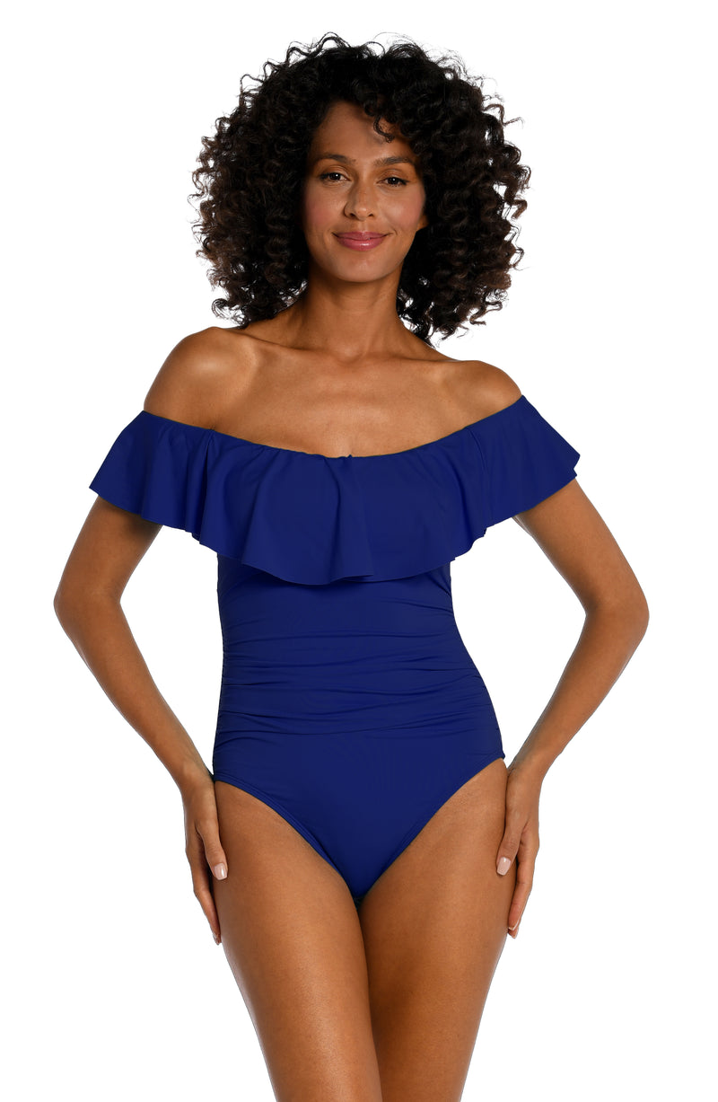 Front image of model wearing an Island Goddess Off Shoulder Ruffle One Piece in Blueberry.