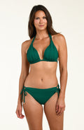 Woman wearing a green bikini top and matching bottom against a white background. 