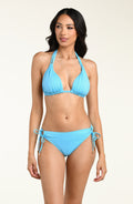 Woman wearing a light blue bikini top and matching bottom against a white background. 