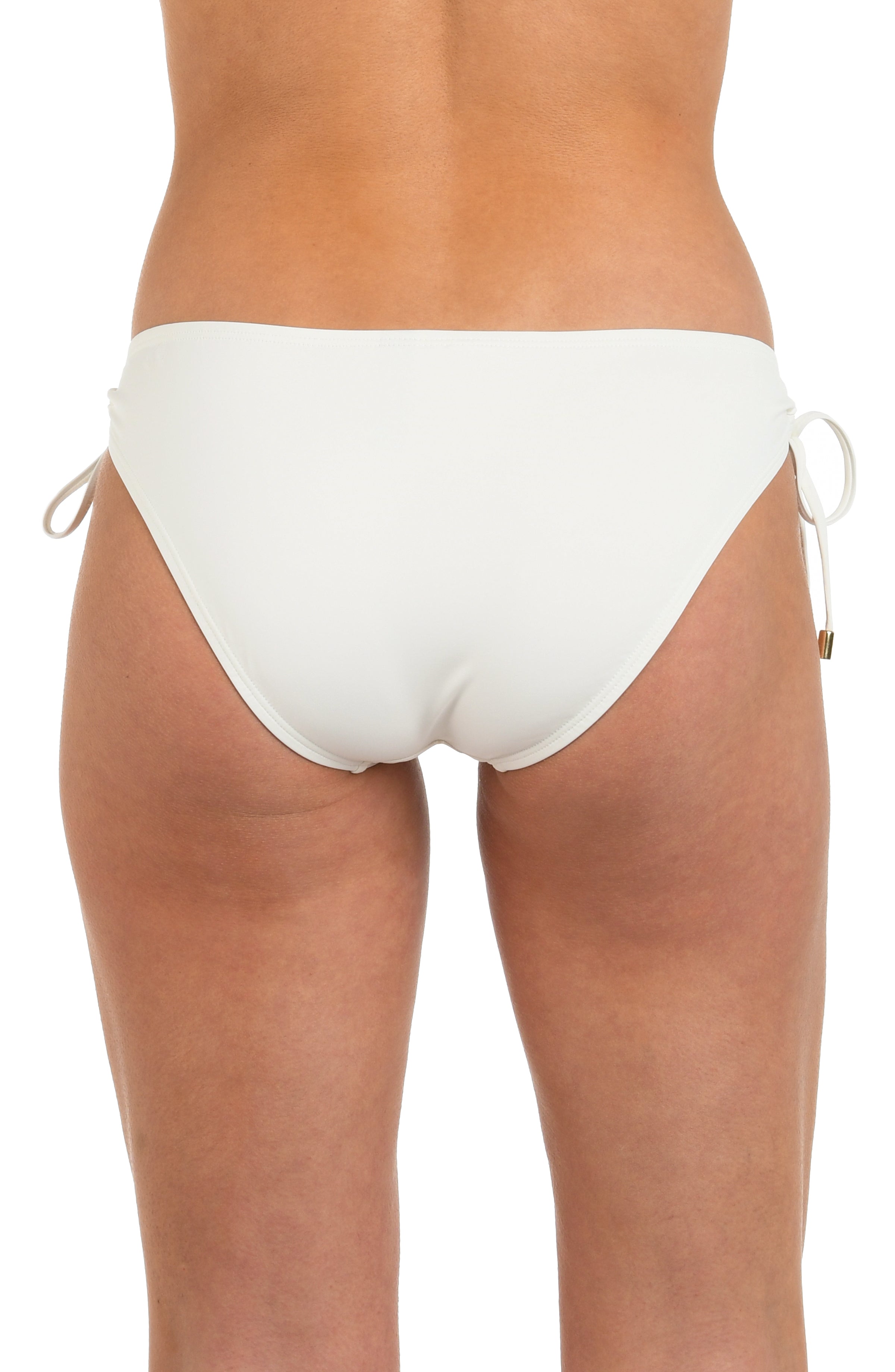 Back image of model wearing an ivory colored hipster bikini bottom featuring adjustable loop side ties with gold cord ends, and moderate rear coverage. 