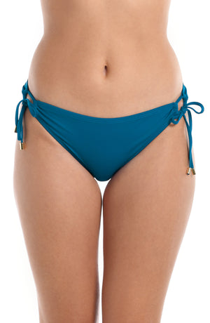 Model is wearing a ocean colored side-tie swimsuit bottom from our Best-Selling Island Goddess collection.