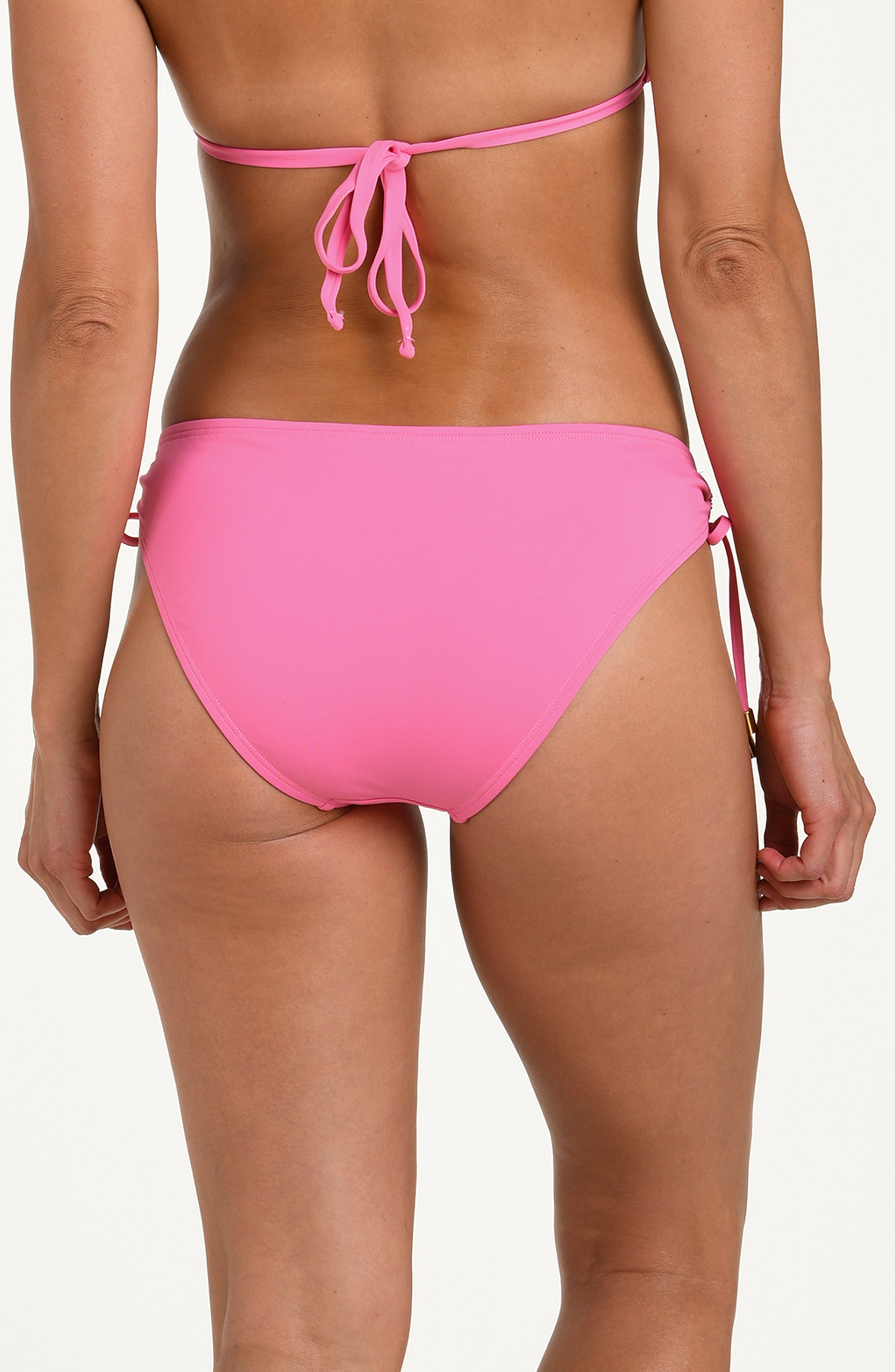 Back image of model wearing a rose pink colored bikini bottoms with adjustable side ties accented with gold tips.