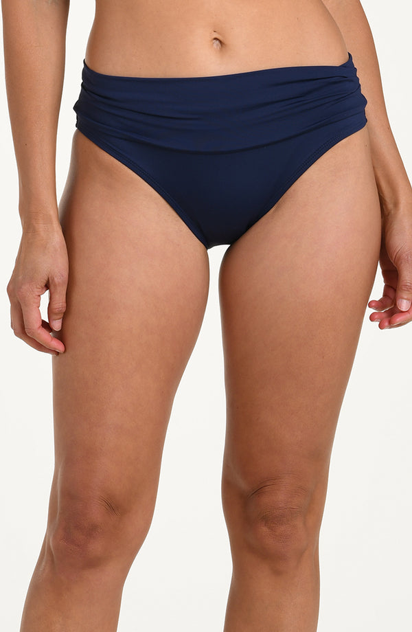 Front image of model wearing an indigo (navy blue) colored bikini bottoms with a wide, ruched waistband.