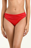 Woman wearing red bikini bottoms against a white background.