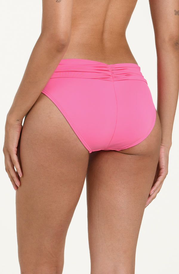 Back image of model wearing rose pink colored bikini bottoms with a wide, ruched waistband and moderate rear coverage.