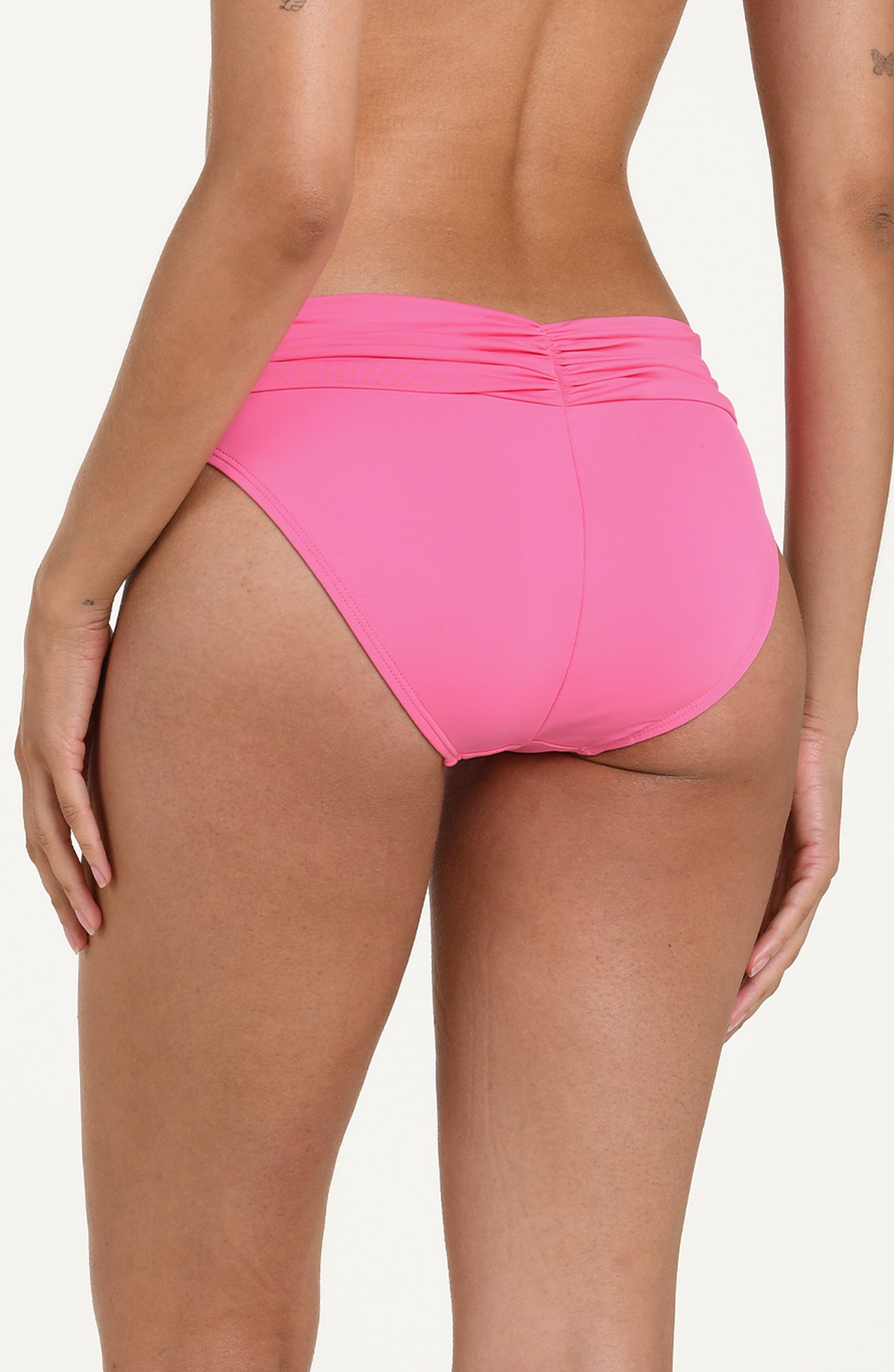 Back image of model wearing rose pink colored bikini bottoms with a wide, ruched waistband and moderate rear coverage.