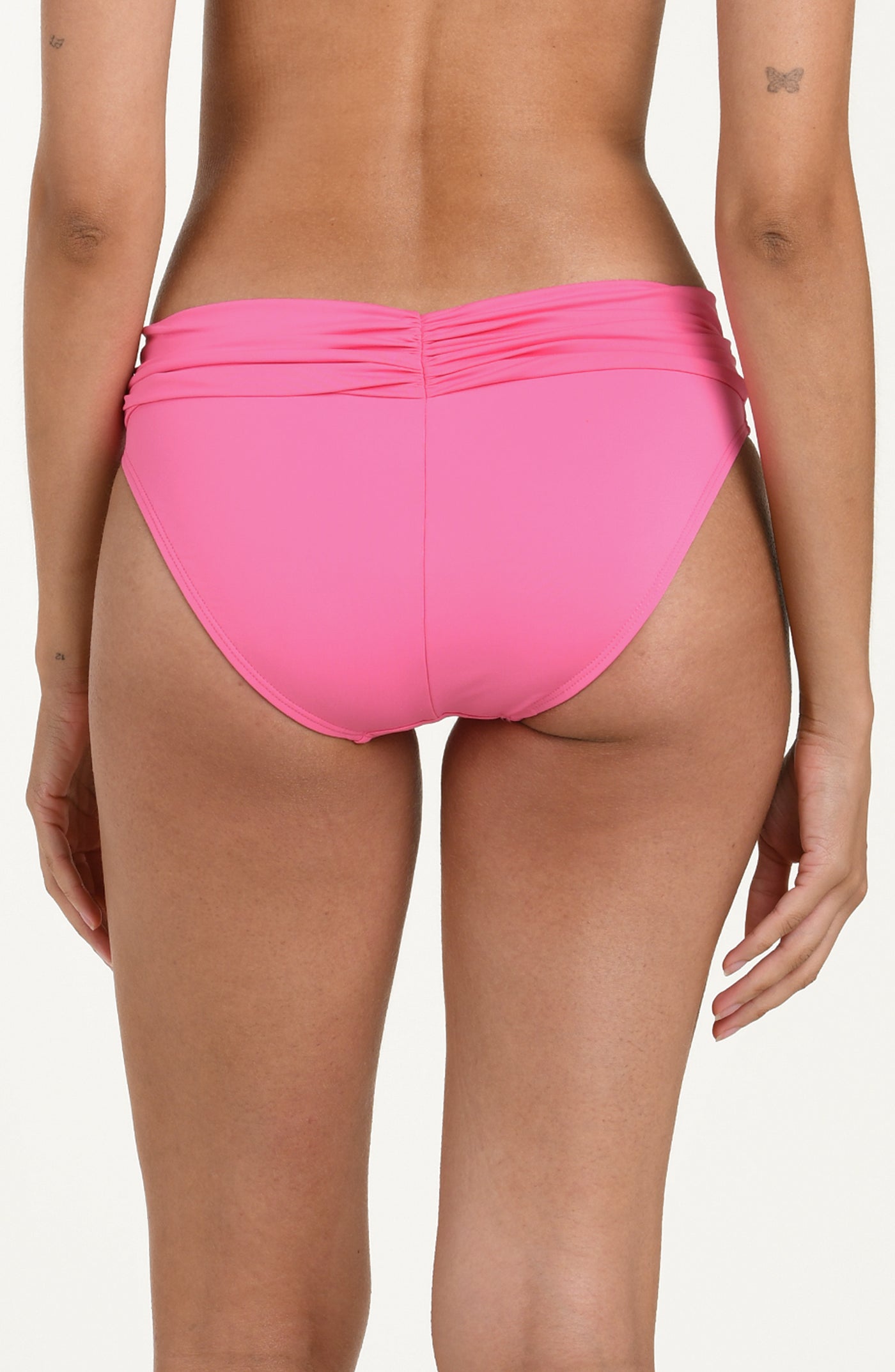 Back image of model wearing rose pink colored bikini bottoms with a wide, ruched waistband and moderate rear coverage.