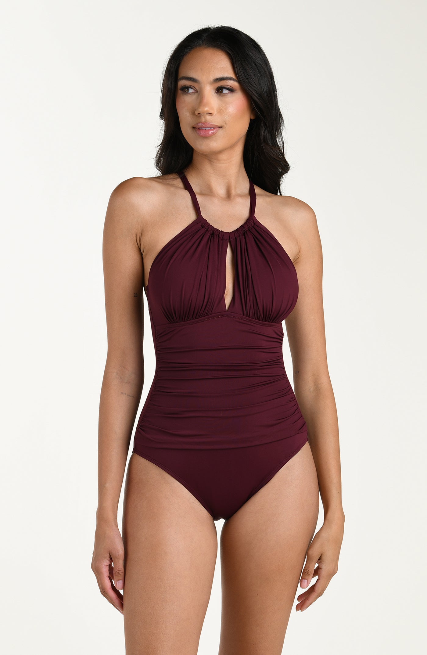 
                  
                    Front image of model wearing a dark cherry colored one-piece swimsuit with a halter neckline, keyhole cutout, and ruched detailing at the waist.
                  
                