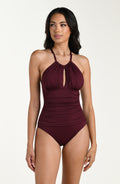 Front image of model wearing a dark cherry colored one-piece swimsuit with a halter neckline, keyhole cutout, and ruched detailing at the waist.