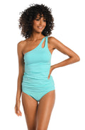 Woman wearing an ice blue one-shoulder swimsuit on a white background