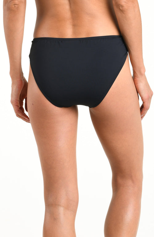 Woman wearing a solid black bikini bottom with beaded sides against a white background. 