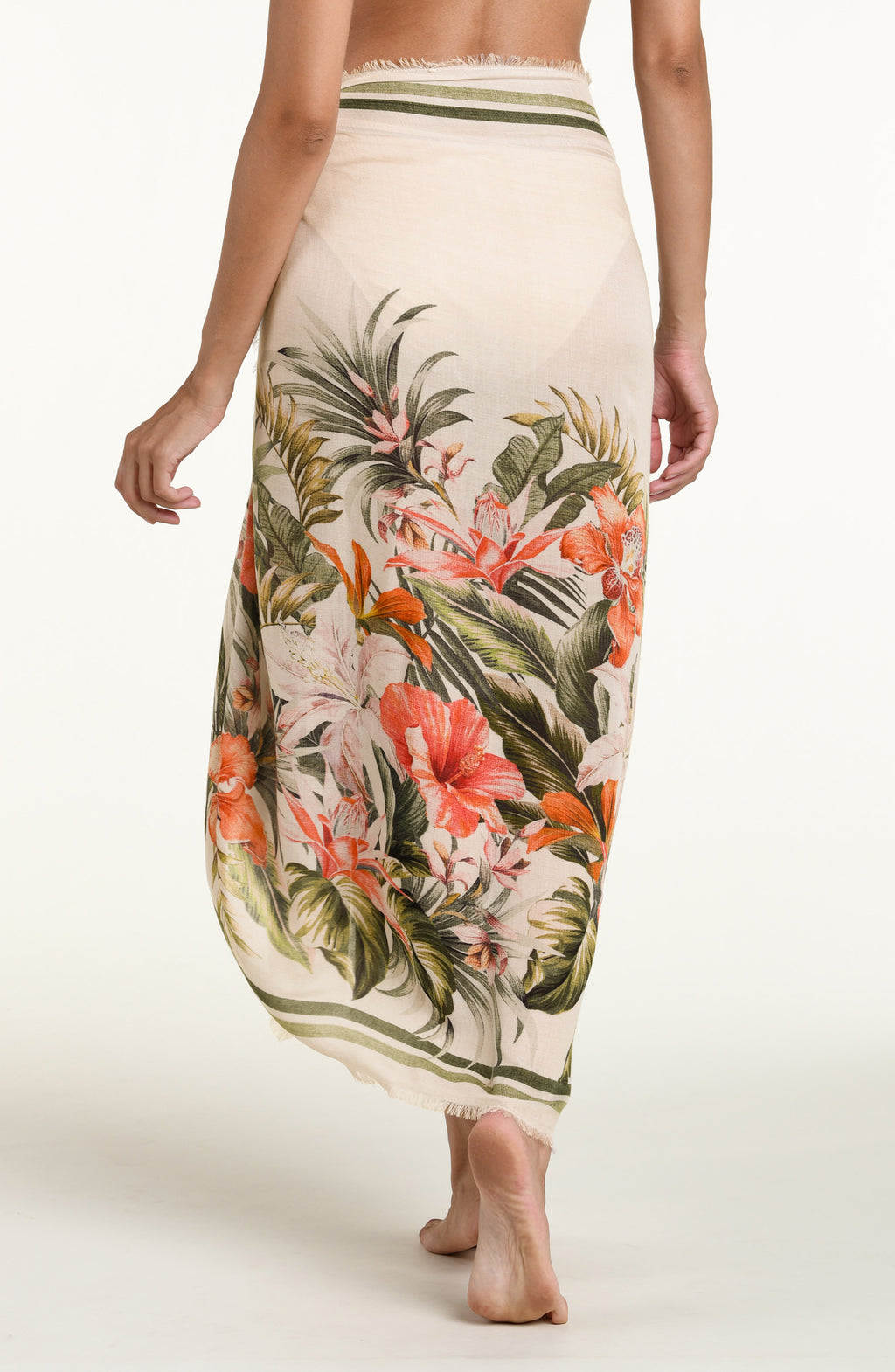 Woman wearing a white multicolored pareo wrap cover up against a white background. 