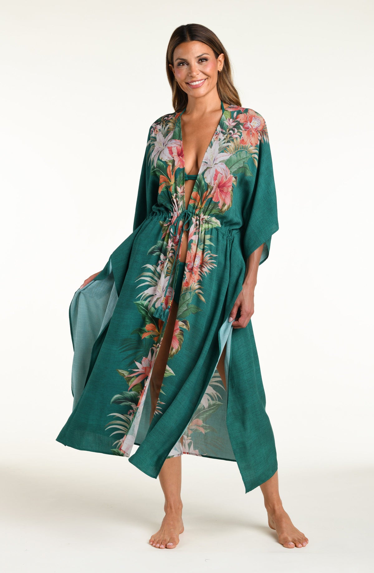 Woman wearing a jungle green multicolored long kimono against a white background. 