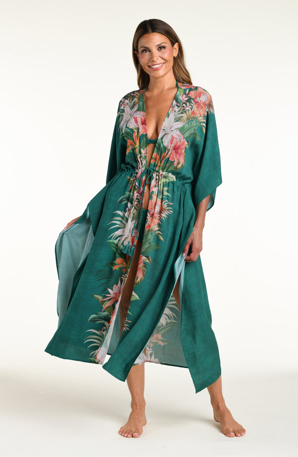 Woman wearing a jungle green multicolored long kimono against a white background. 