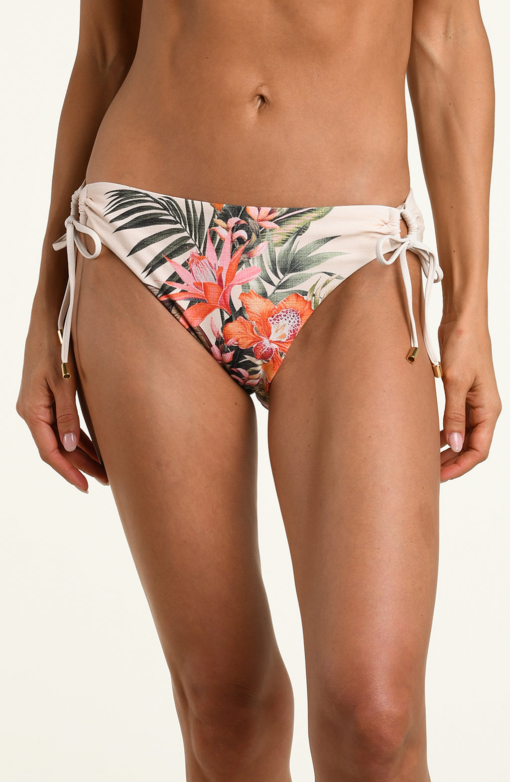 Woman wearing a multicolored white bikini bottom against a white background. 