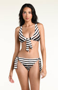 A woman modeling a brown and white horizontally striped two-piece bikini with a tie-front top and side-tie bottoms against a plain light background.