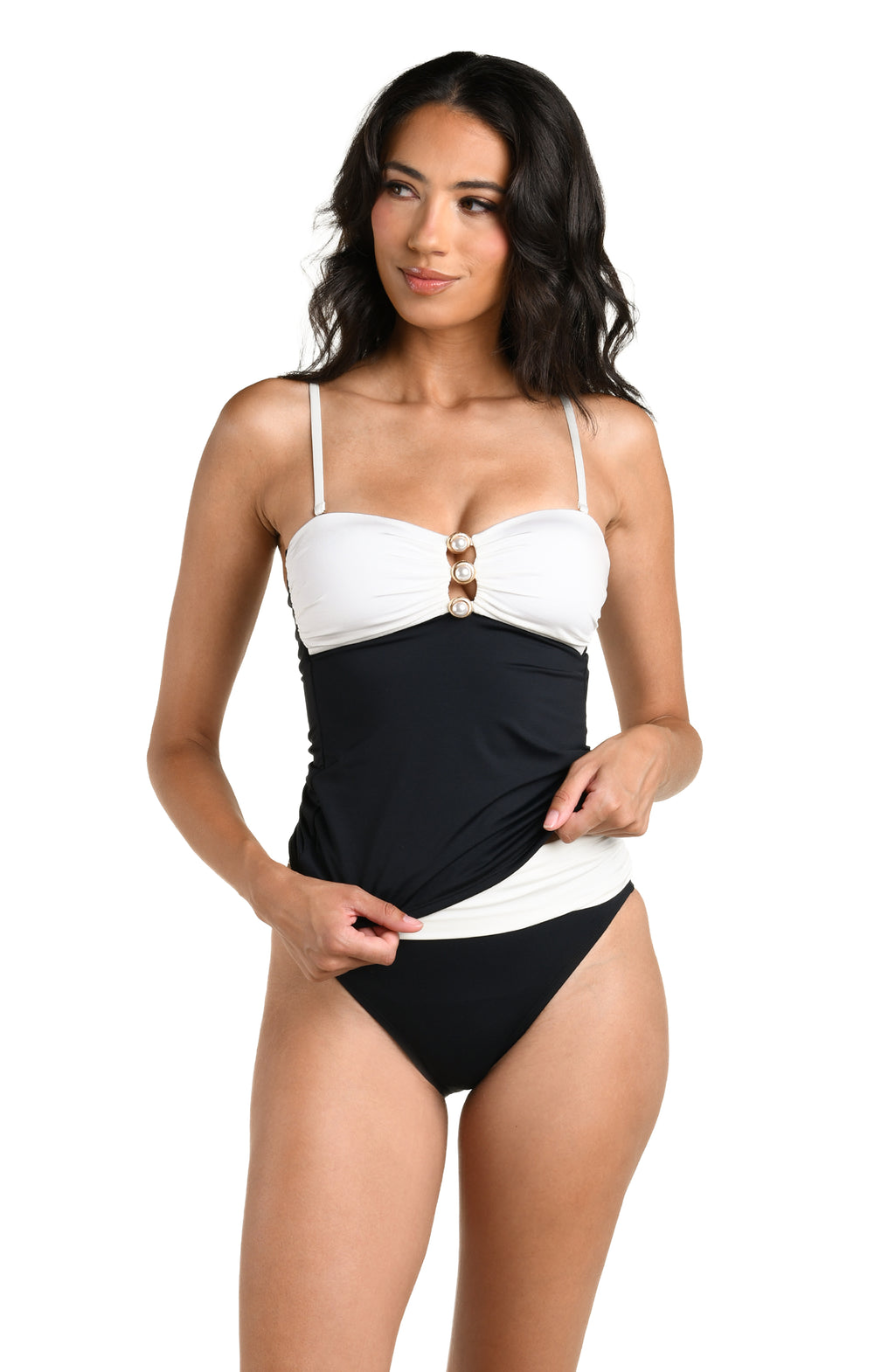 A woman wearing a black and white contrasting tankini top and black bottom against a white background. 