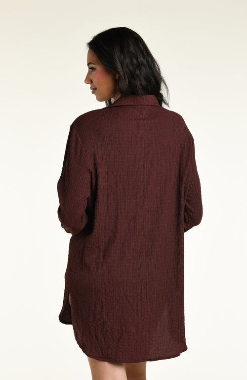 Woman wearing a java brown colored long sleeve cover up top against a white background. 