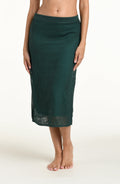 Woman wearing a jungle green crochet midi skirt against a white background. 