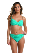 Front image of model wearing a solid eucalyptus colored bikini swimsuit top featuring over the shoulder straps and a wrap front. 

