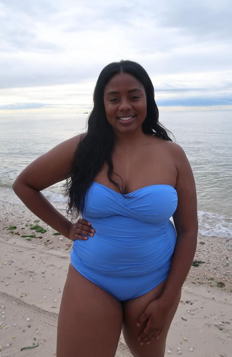 UGC image of woman wearing a solid chambray (light blue) colored bandeau tankini swimsuit top.