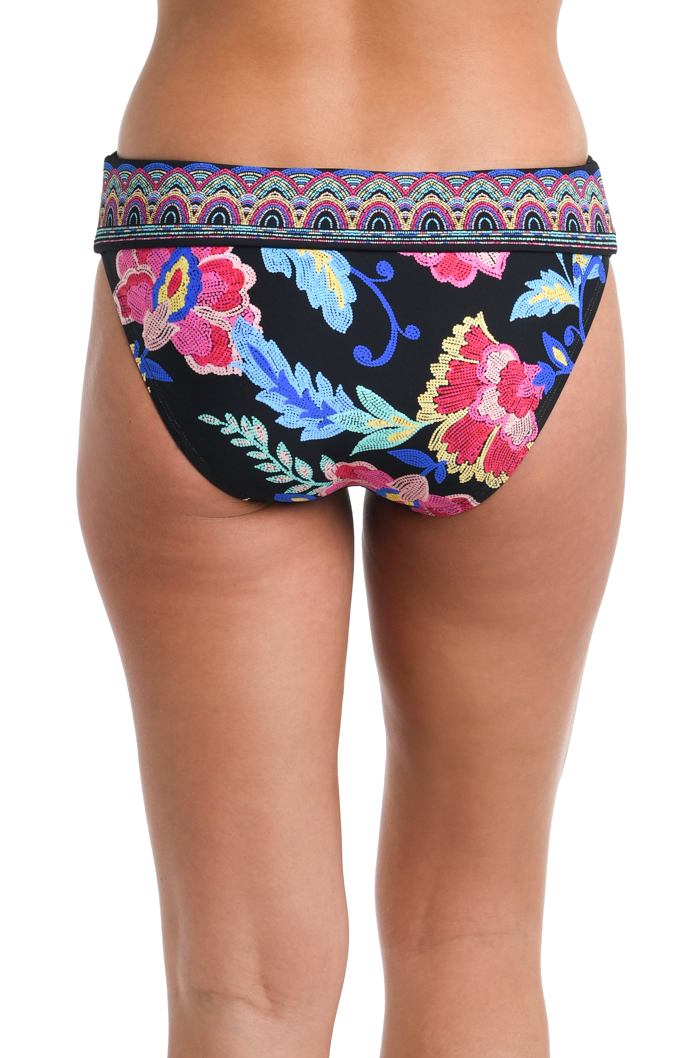 Back image of model wearing a black, pink, and blue multicolored floral patterned hipster bikini swimsuit bottom featuring a band and moderate rear coverage. 