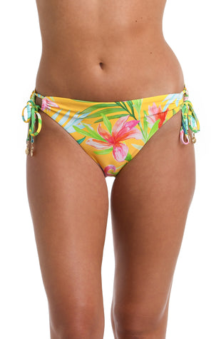 Model is wearing a bright yellow, pink, and green multicolored tropical printed Side Tie Hipster Bottom