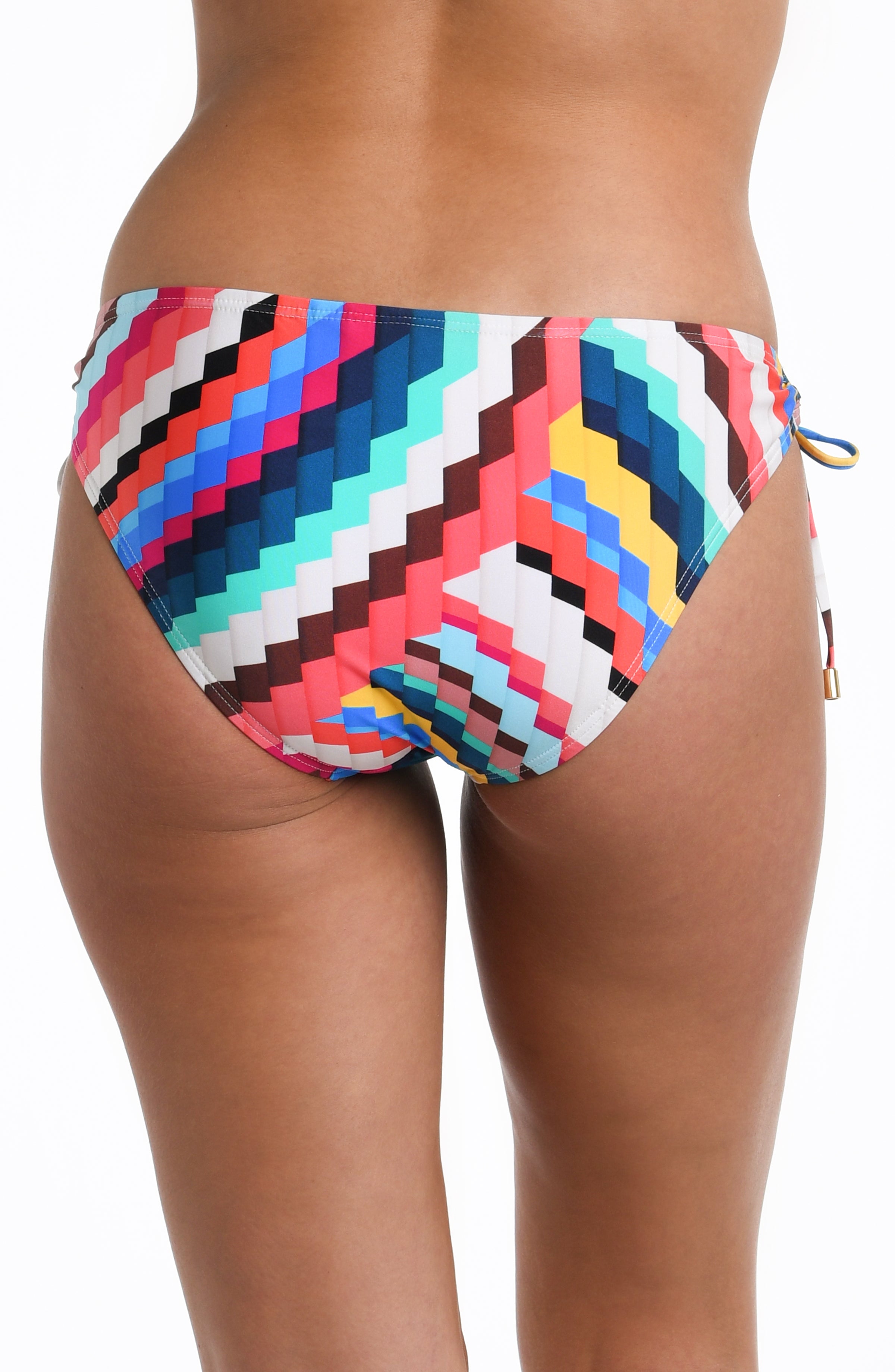 Close-up back image of model wearing a vibrant multi-colored geometric printed bikini swimsuit bottom featuring side ties adorned with tassels and moderate rear coverage.