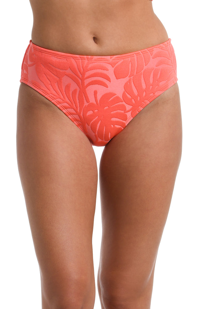 Model is wearing a coral colored palm printed Mid Rise Bottom