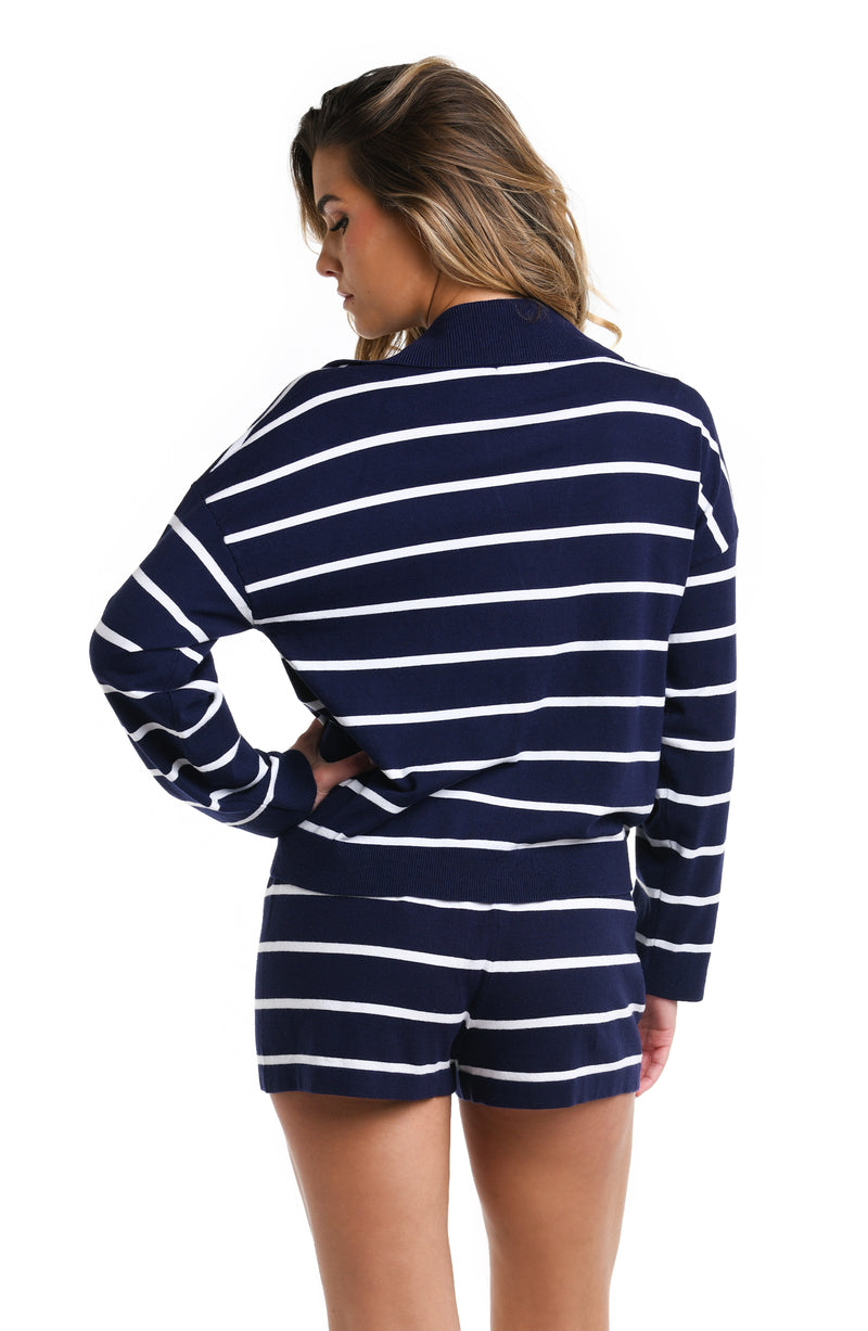 Model is wearing an indigo and white sweater and shorts from the La Blanca Yacht Club collection.