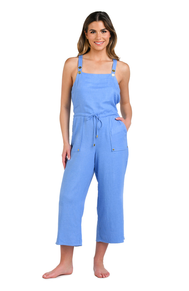 Model is wearing a solid chambray (light blue) colored sleeveless jumpsuit cover up.