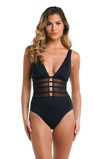 Model is wearing a multicolored Island Goddess Mesh Over The Shoulder One Piece Swimsuit