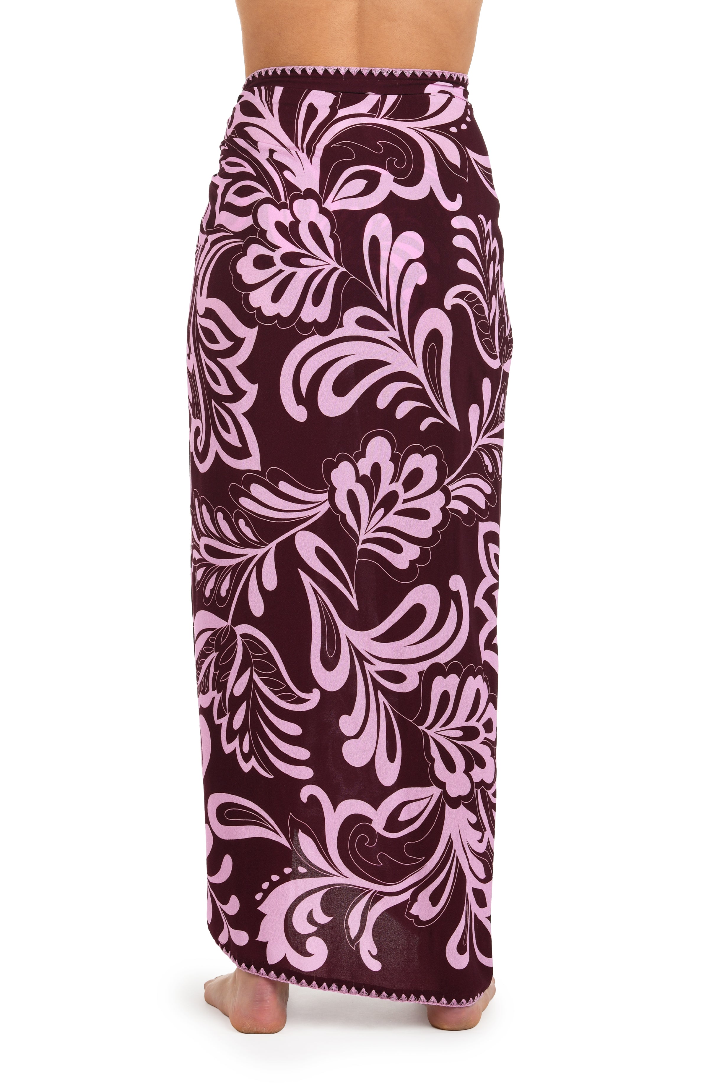 Back image of model wearing a dark cherry and pink tropical patterned pareo wrap cover up. 
