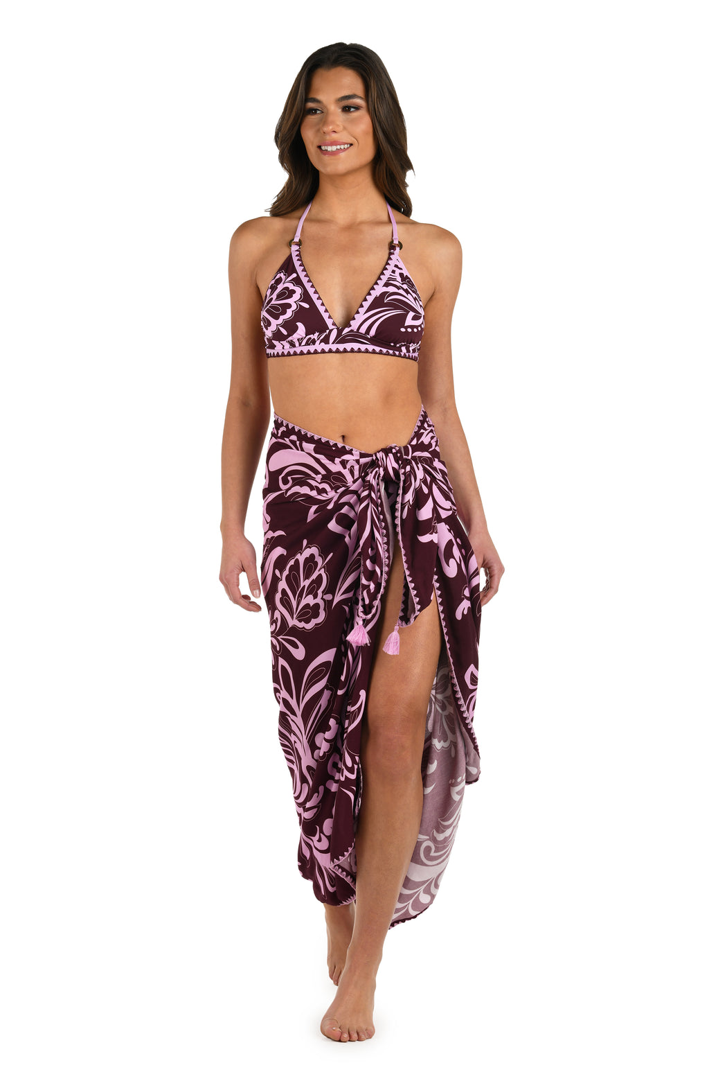 Full body front image of model wearing a dark cherry and pink tropical patterned pareo wrap cover up. 