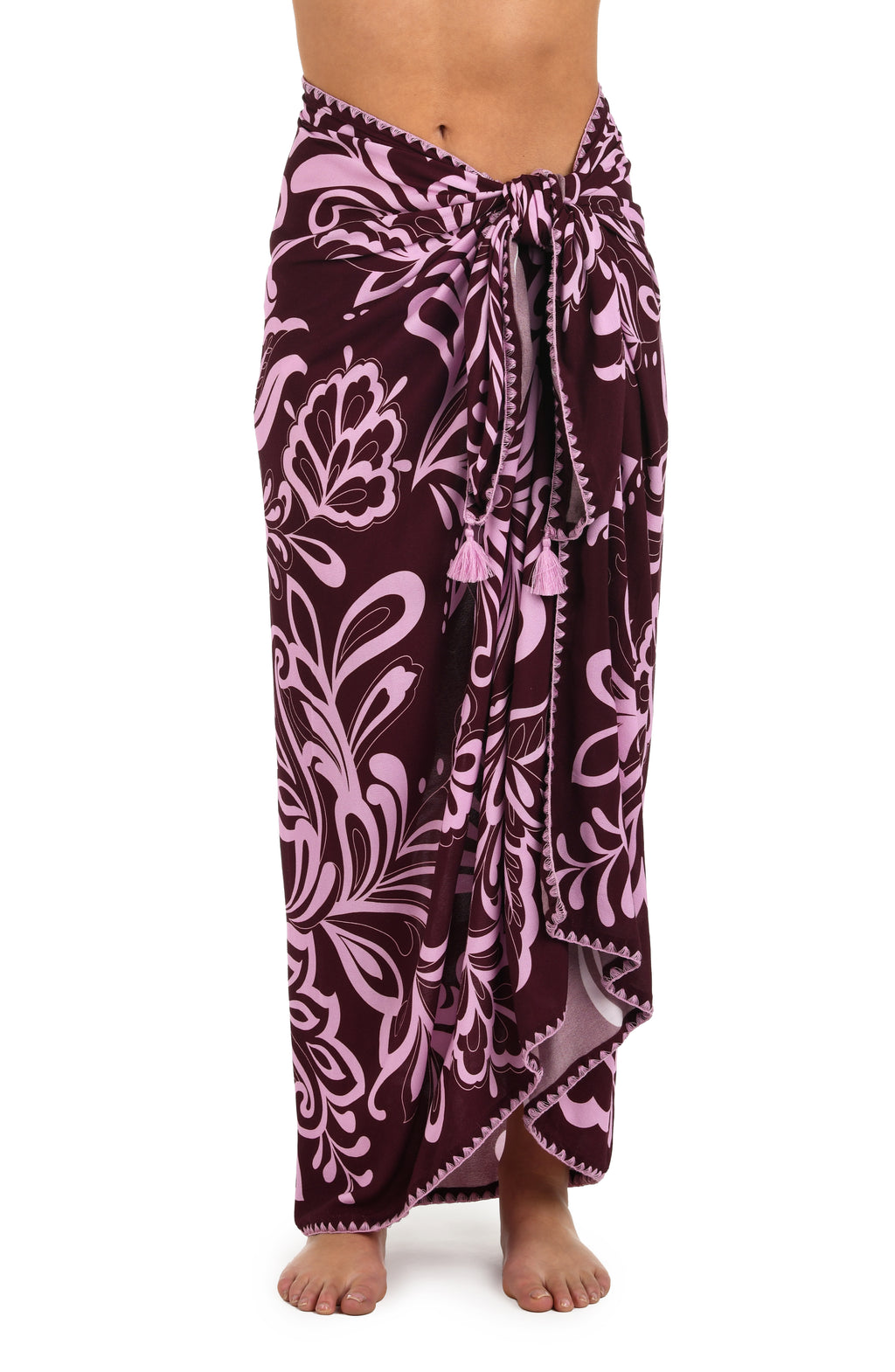 Front image of model wearing a dark cherry and pink tropical patterned pareo wrap cover up. 