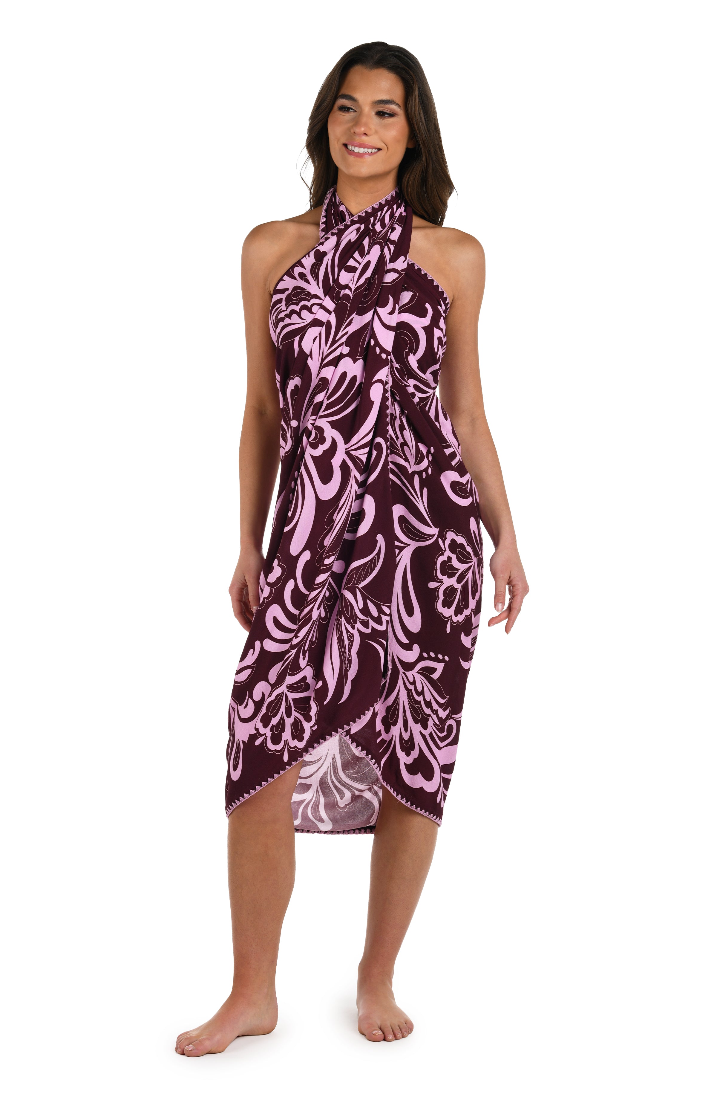 Full body front image of model wearing a dark cherry and pink tropical patterned pareo wrap cover up. 