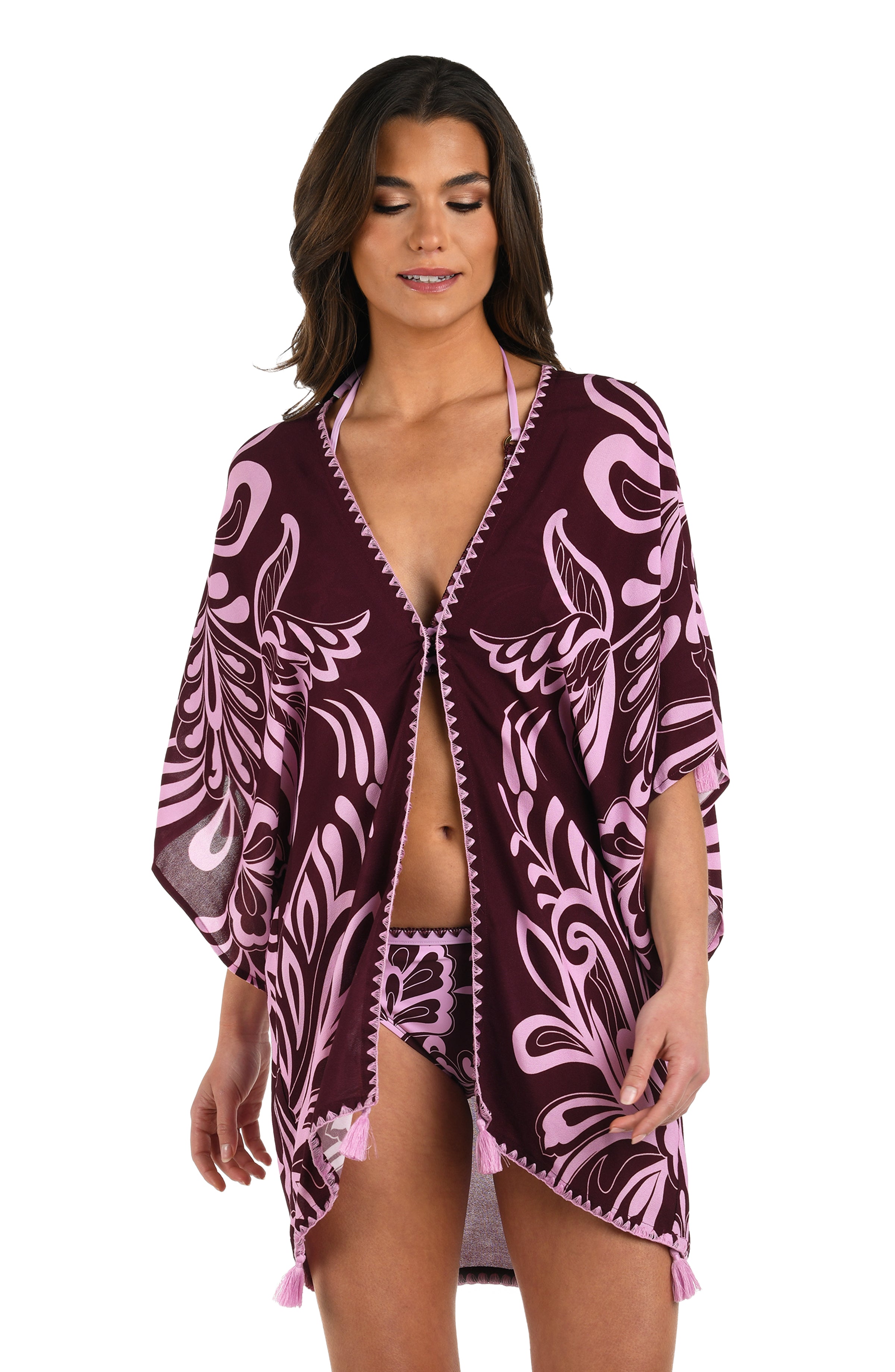 Front image of model wearing a dark cherry and pink tropical patterned open front kimono cover up that is closed with a hook & eye closure. 