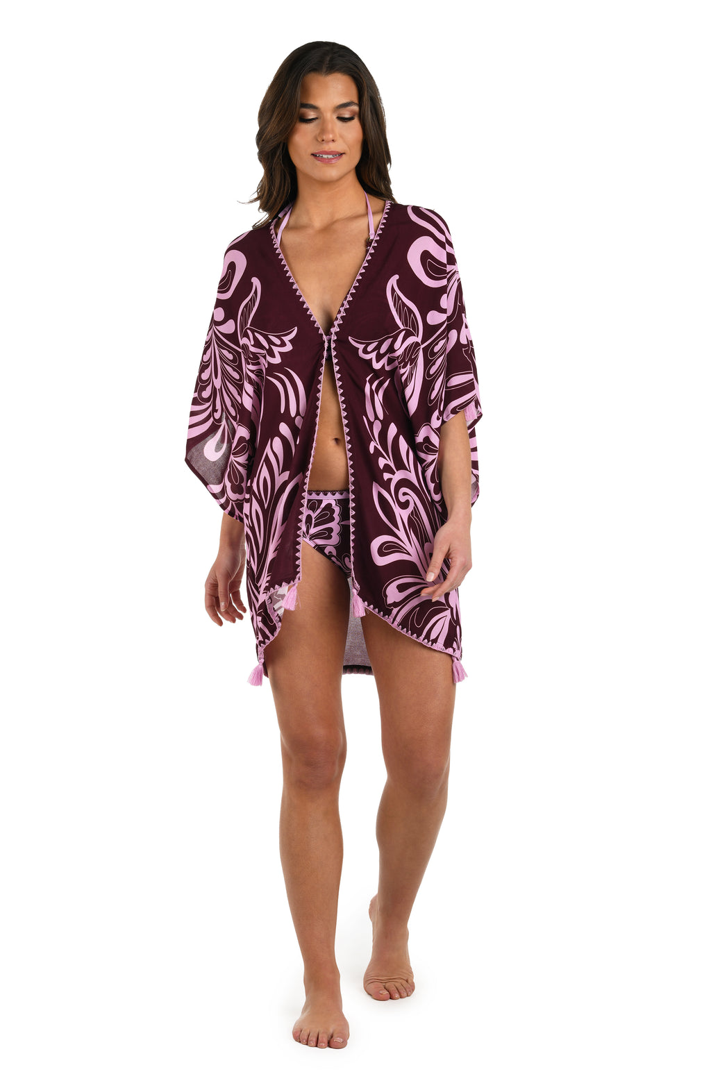 Full body front image of model wearing a dark cherry and pink tropical patterned open front kimono cover up that is closed with a hook & eye closure. 