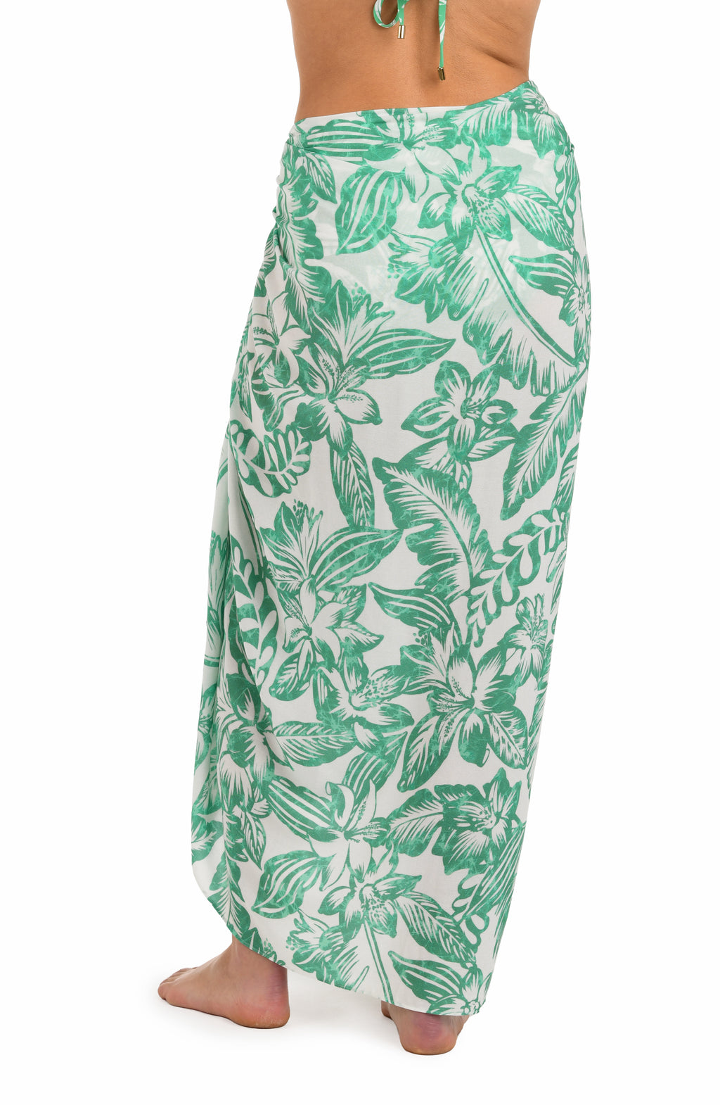 Back image of model wearing a green and white tropical-print pareo wrap cover up. 