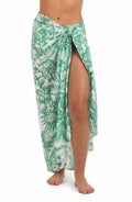 Front image of model wearing a green and white tropical-print pareo wrap cover up. 