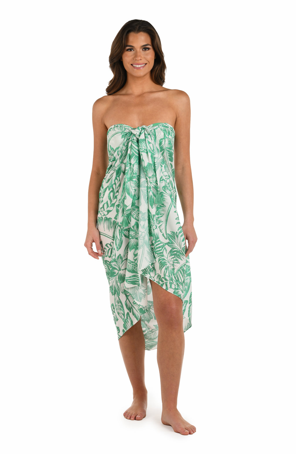 Full body front image of model wearing a green and white tropical-print pareo wrap cover up. 
