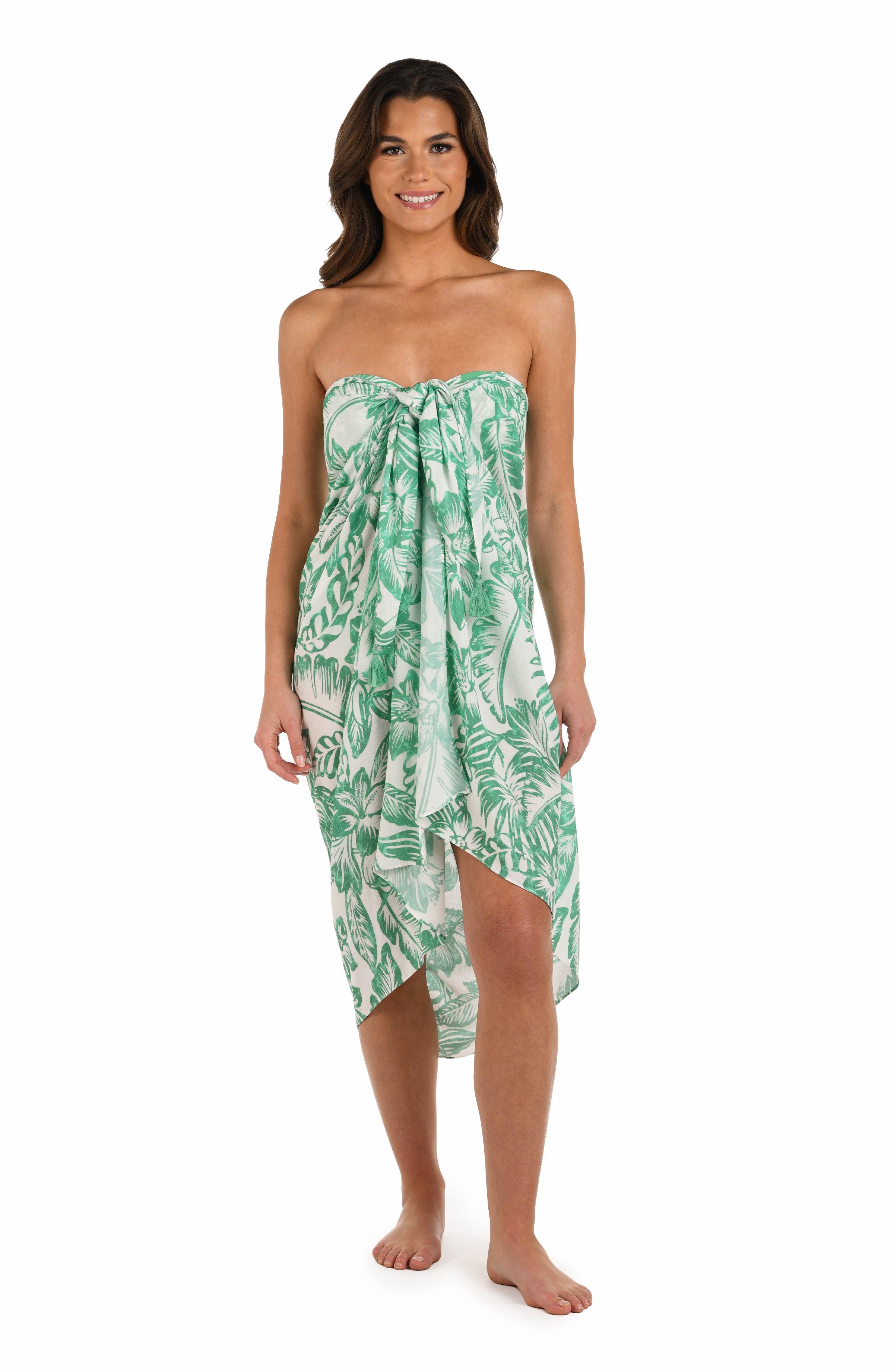Full body front image of model wearing a green and white tropical-print pareo wrap cover up. 