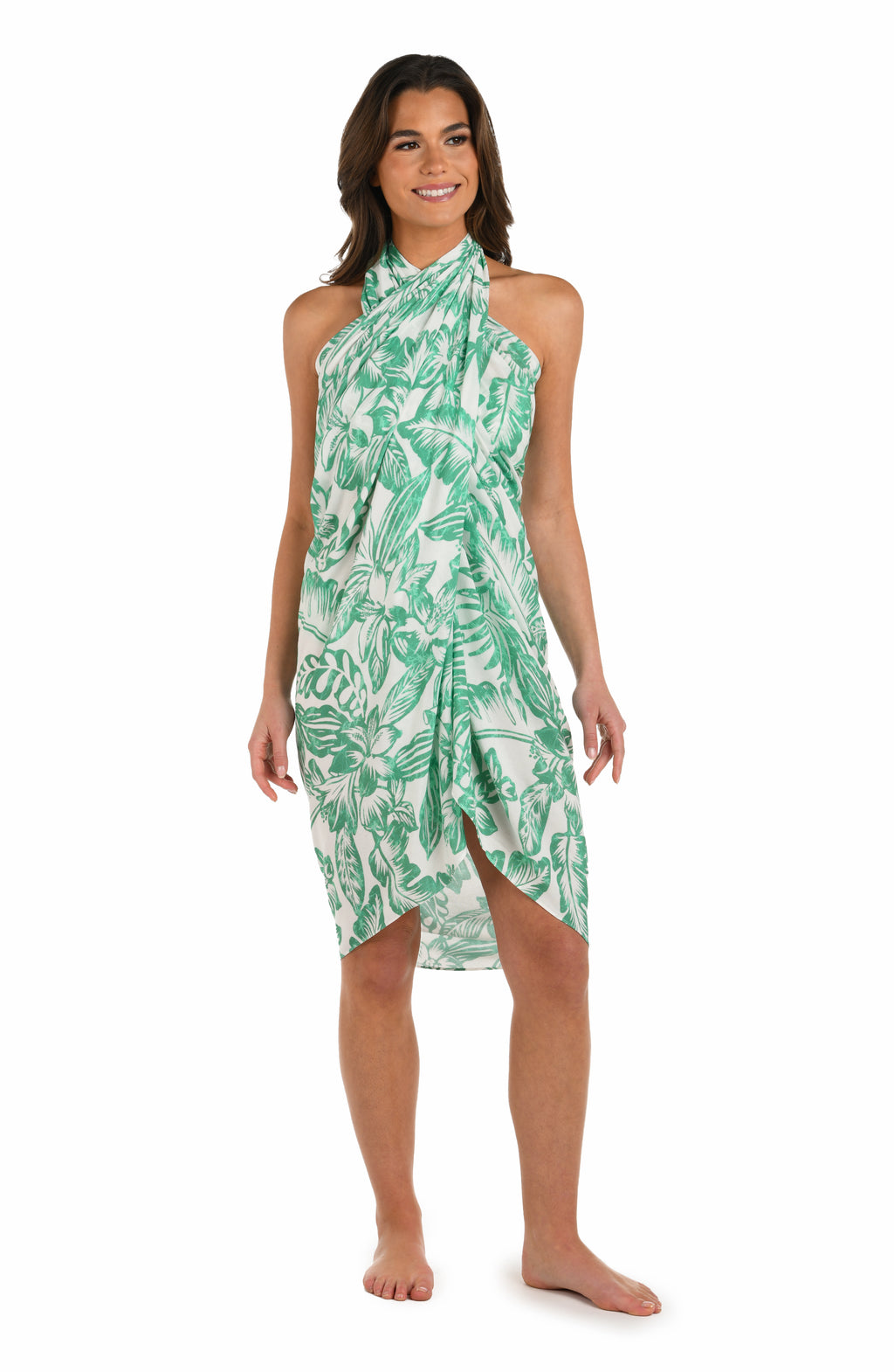 Full body front image of model wearing a green and white tropical-print pareo wrap cover up. 