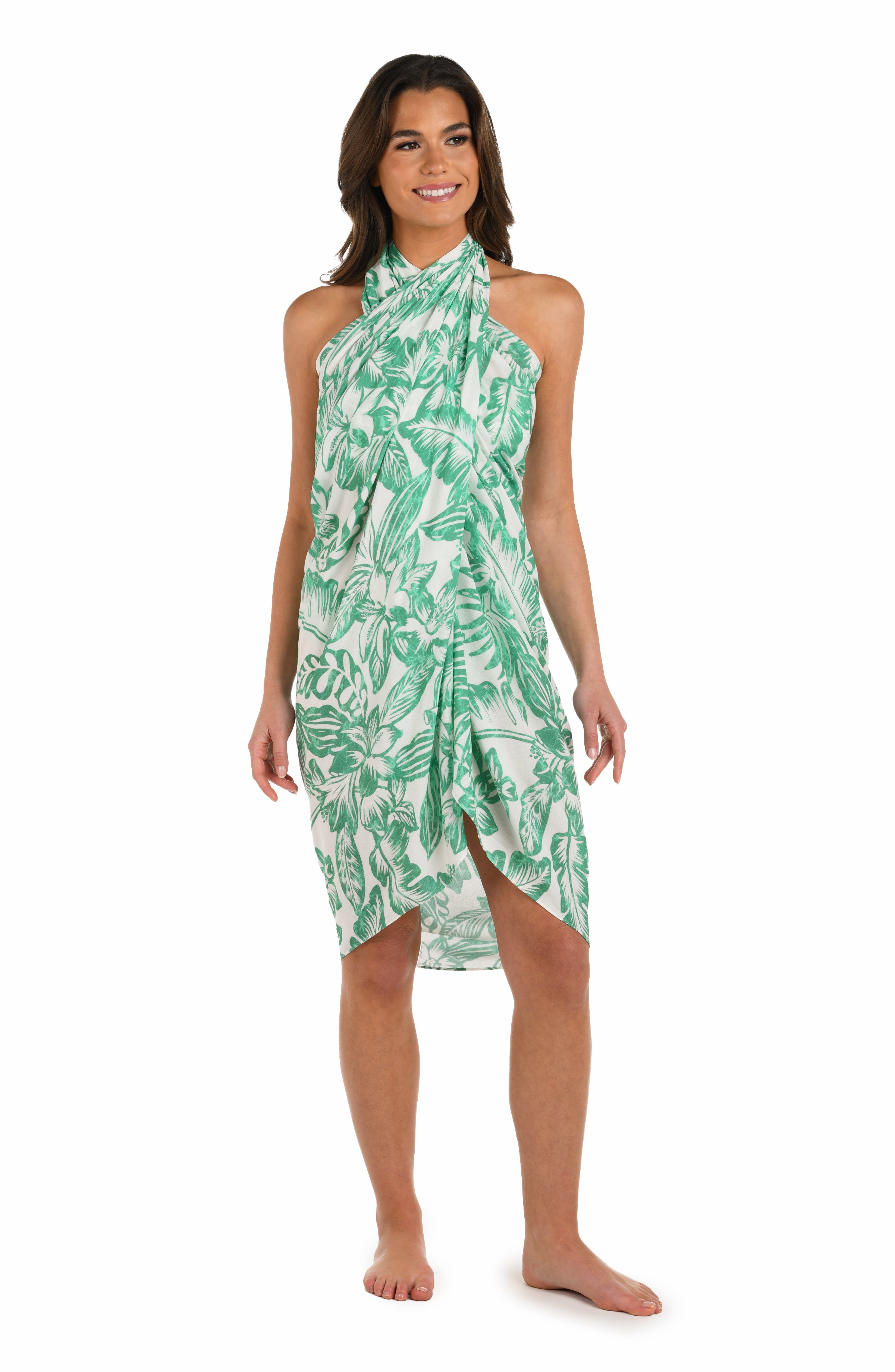 Full body front image of model wearing a green and white tropical-print pareo wrap cover up. 