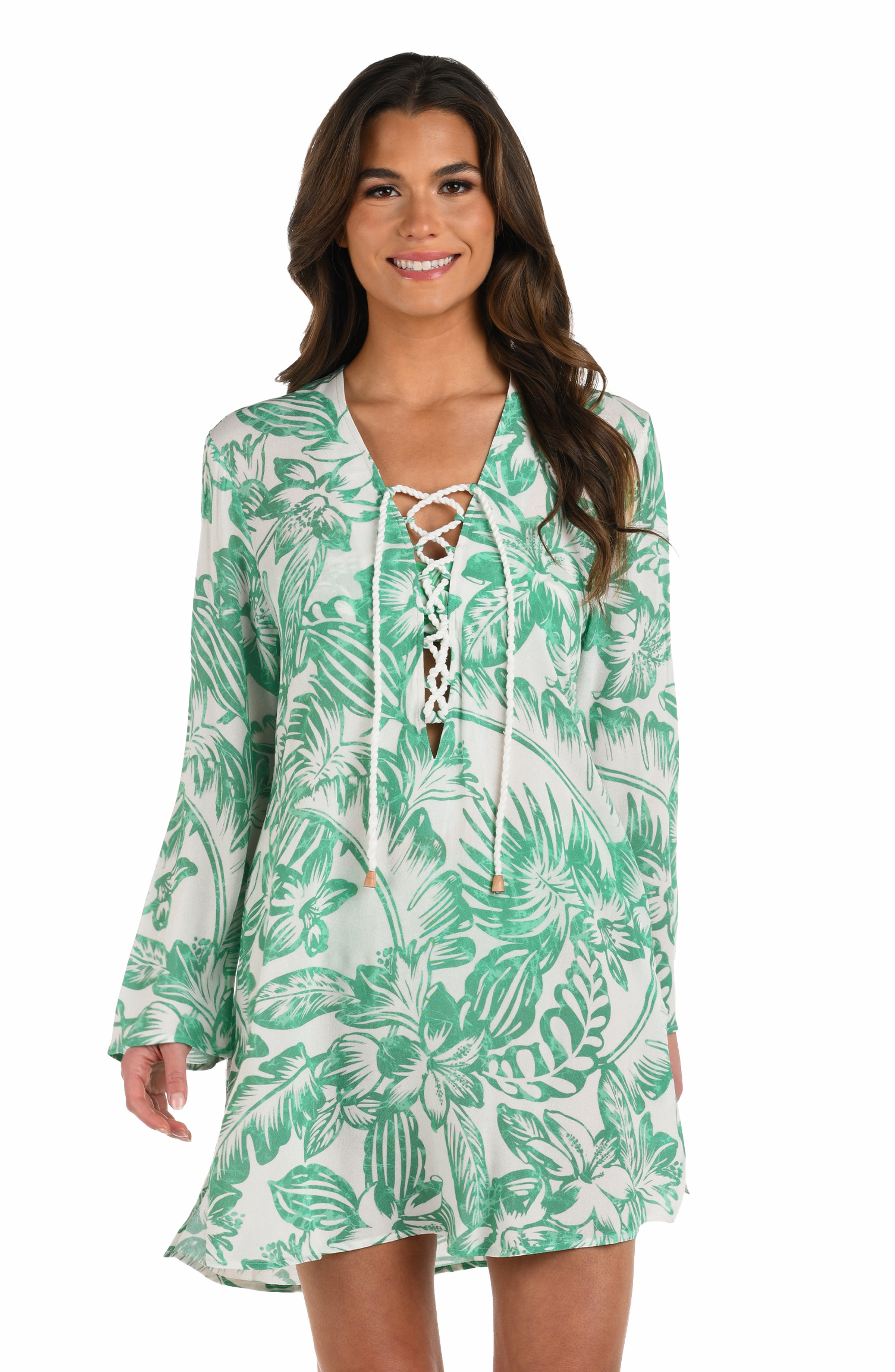Front image of model wearing a green and white floral-printed long-sleeve tunic with a lace-up neckline and side pockets.