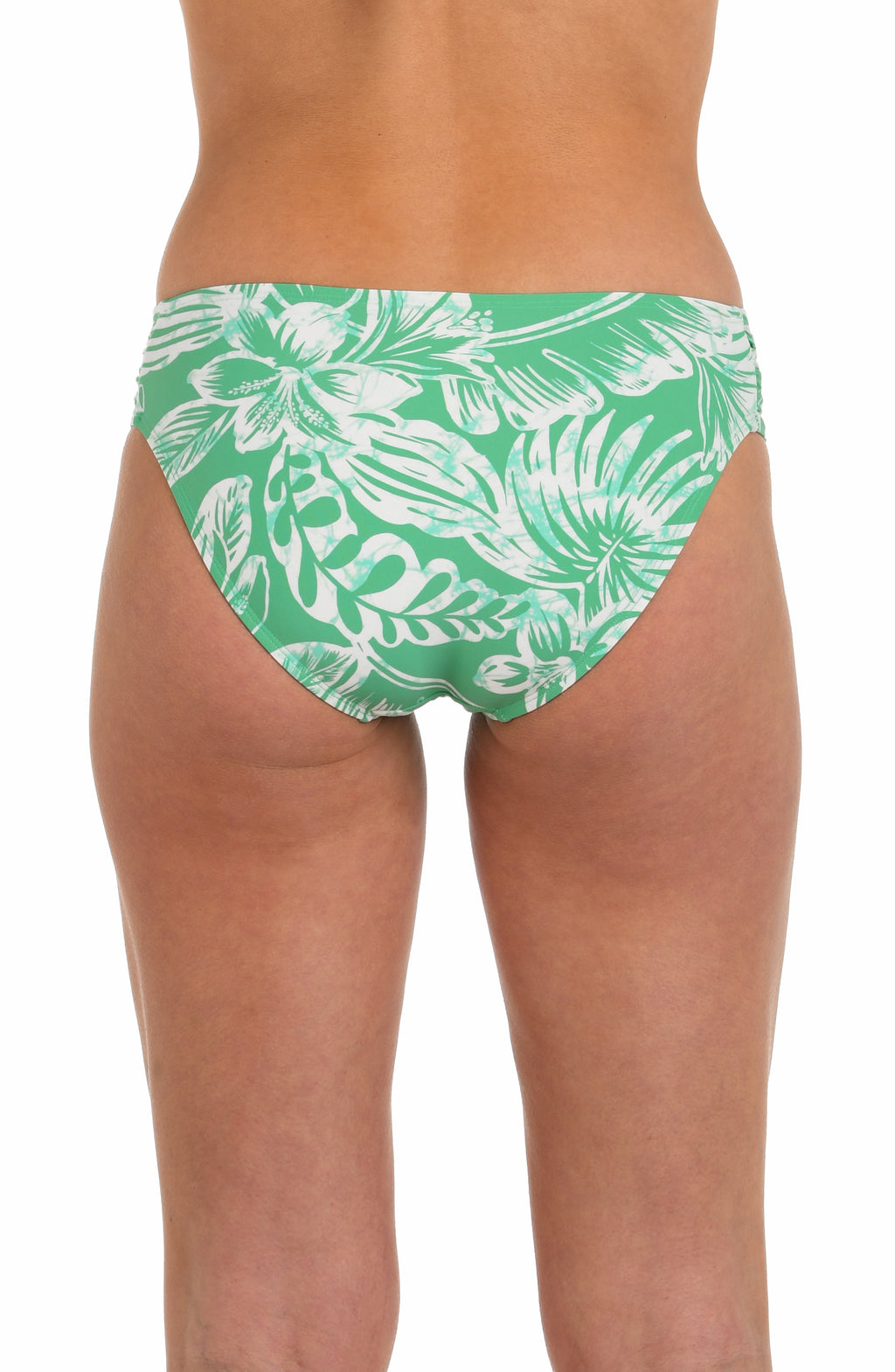 Back image of model wearing a green and white floral-printed hipster bikini bottom featuring shirred sides, and moderate rear coverage.
