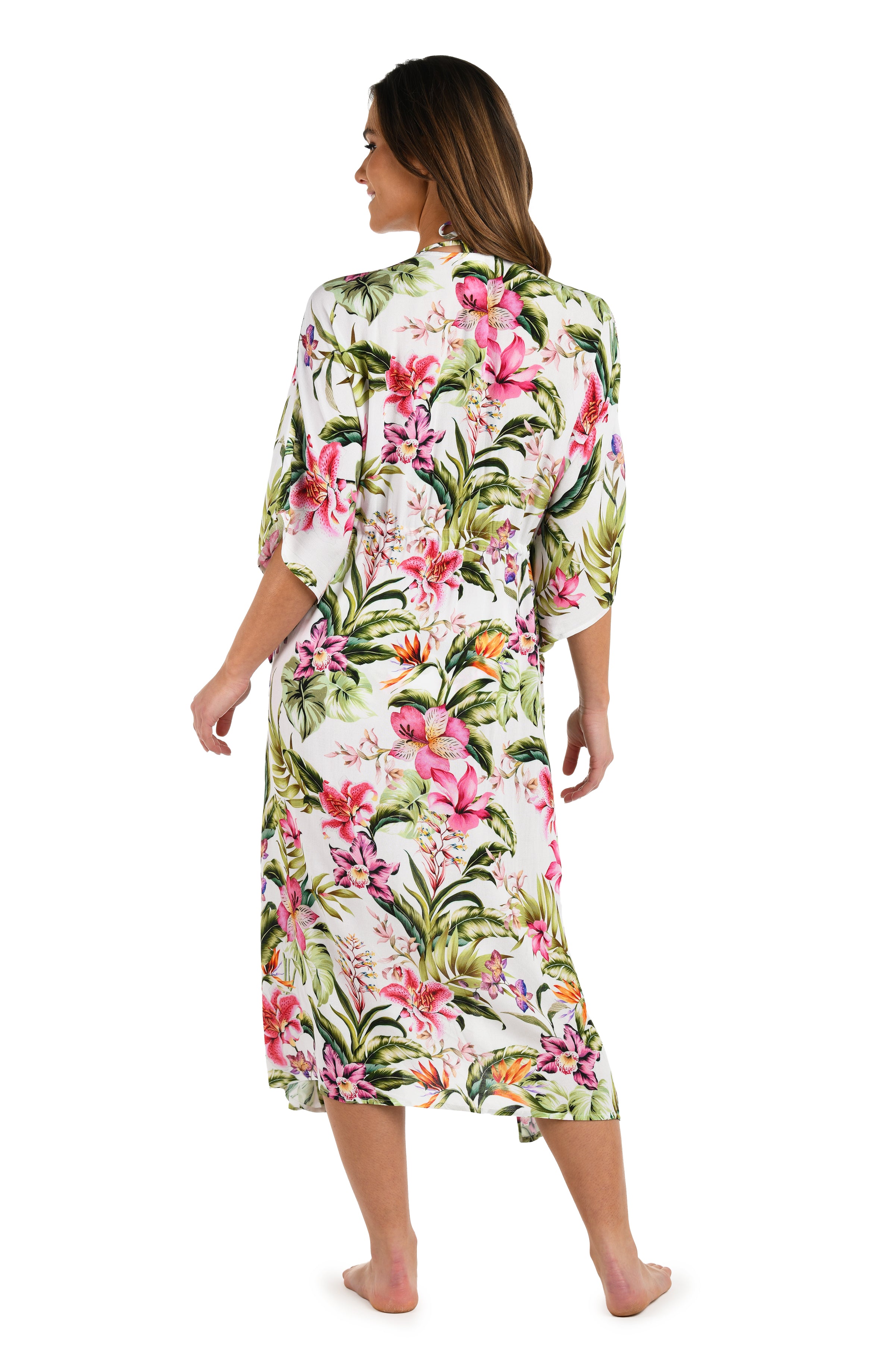 Full body back image of model wearing a long floral kimono cover-up featuring a deep V-neckline, flowy three-quarter sleeves, and a vibrant tropical print on lightweight fabric.