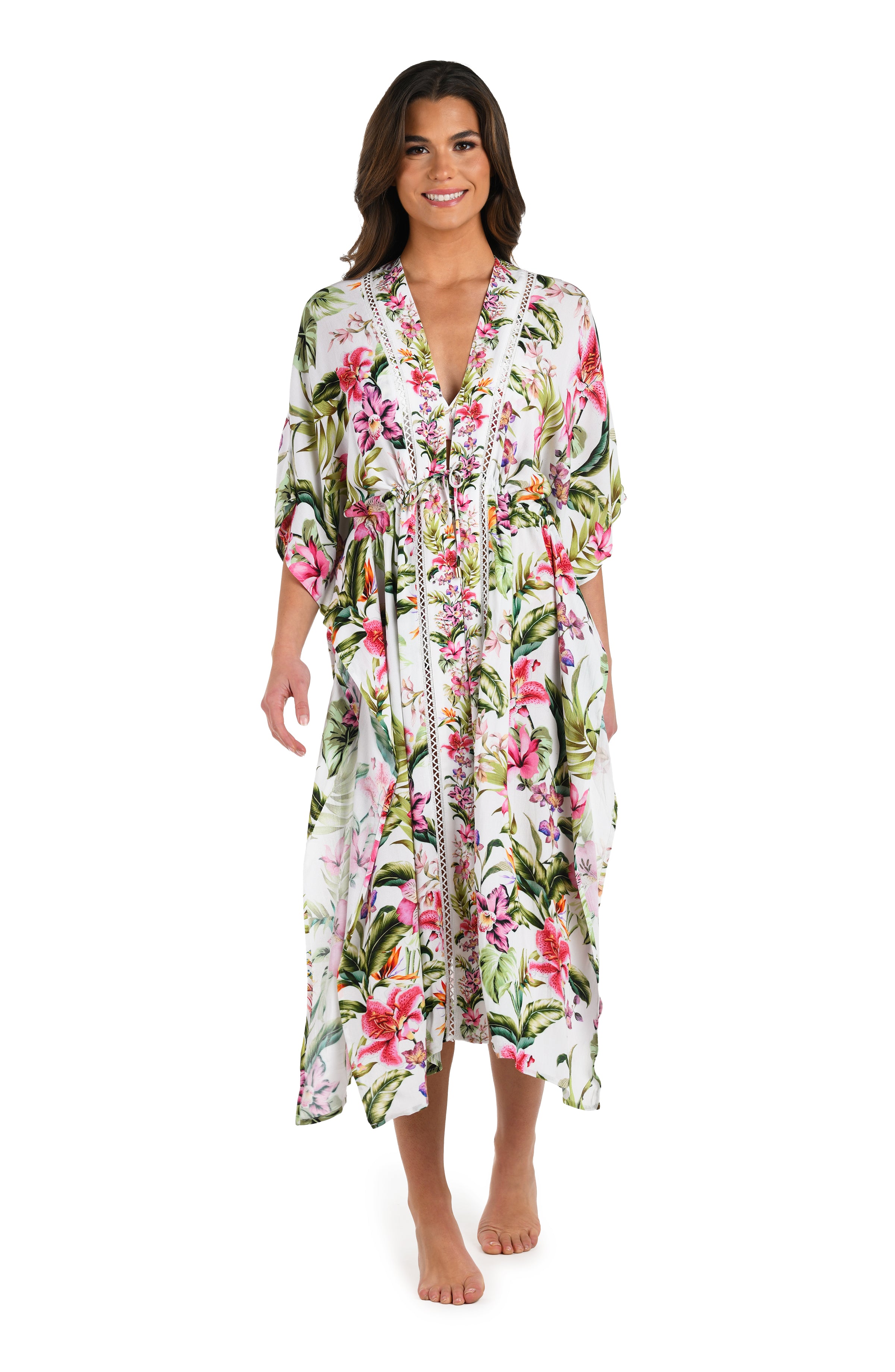 Full body front image of model wearing a long floral kimono cover-up featuring a deep V-neckline, flowy three-quarter sleeves, and a vibrant tropical print on lightweight fabric.