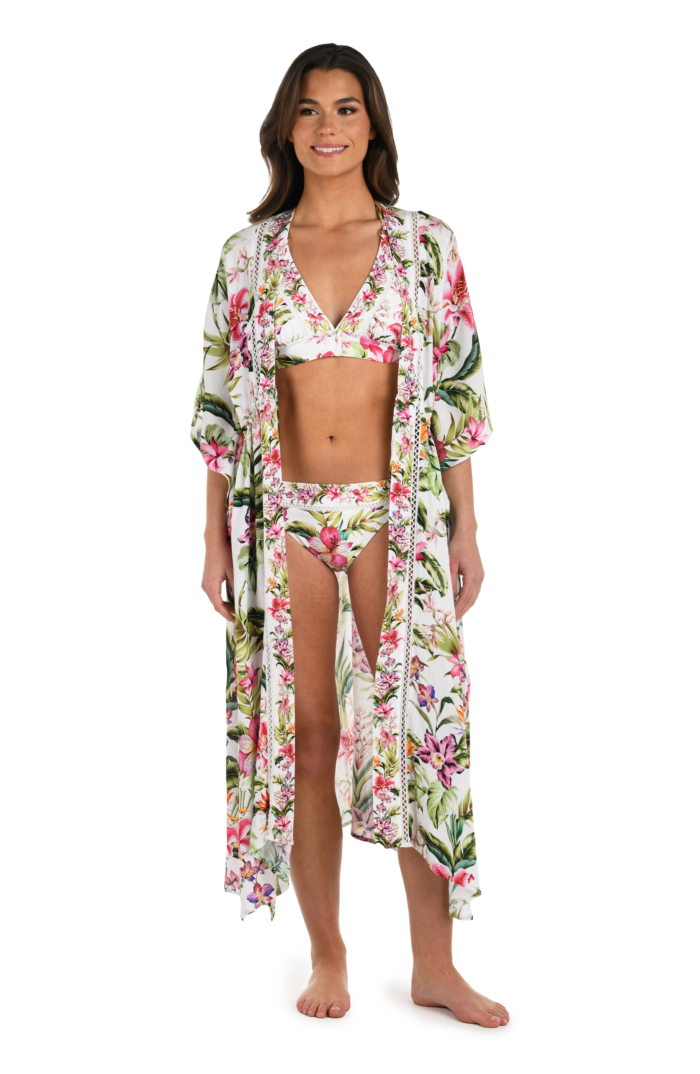Full body front image of model wearing a long floral kimono cover-up featuring a deep V-neckline, flowy three-quarter sleeves, and a vibrant tropical print on lightweight fabric.