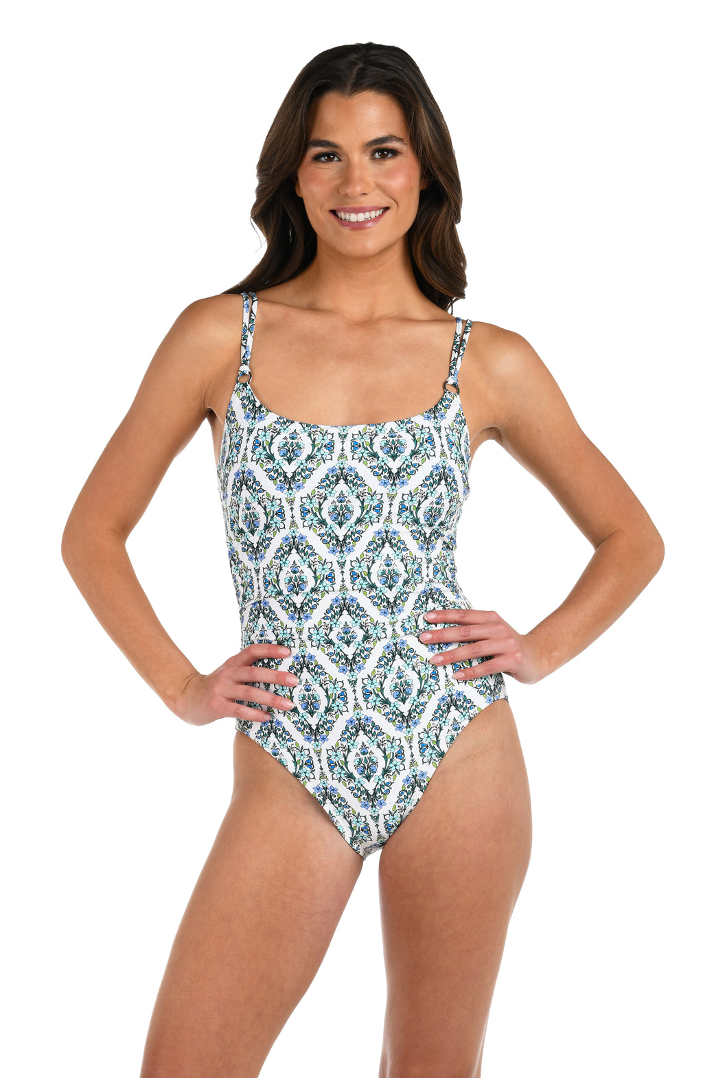 Front image of model wearing a one-piece swimsuit with a blue and green tile-inspired print, featuring thin over the shoulder straps. 